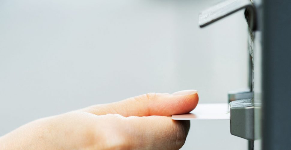 Closeup of female hand with a credit card and ticket vending machine